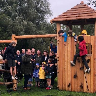a photograph of adults and children beside wooden play equipment. Click, tap or press enter to open a full article
