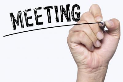 an image of a hand which holds a pencil - it writes MEETING