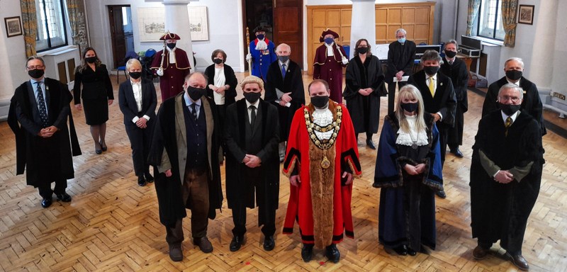 Marlborough Town Council a group of men and women, most wearing ceremonial robes and facemasks, stand facing the camera