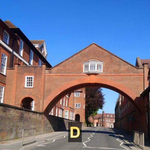 D-a red brick bridge with a window spans a road