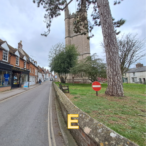 a street with shops on the left and a church on the right