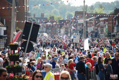 crowds of people in a street, some in hi viz
