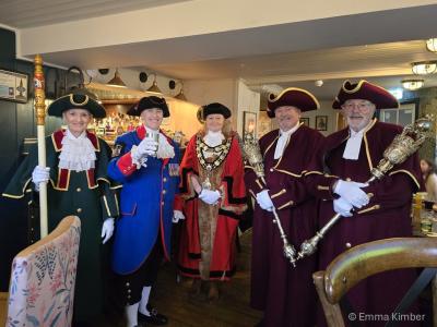 A group of people in ceremonial robes in a pub