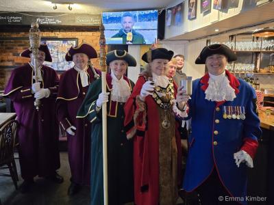A group of people in ceremonial robes in a pub