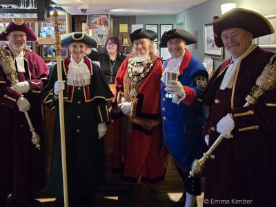 A group of people in ceremonial dress in a pub