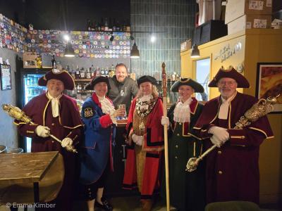 A group of people in ceremonial robes in a pub