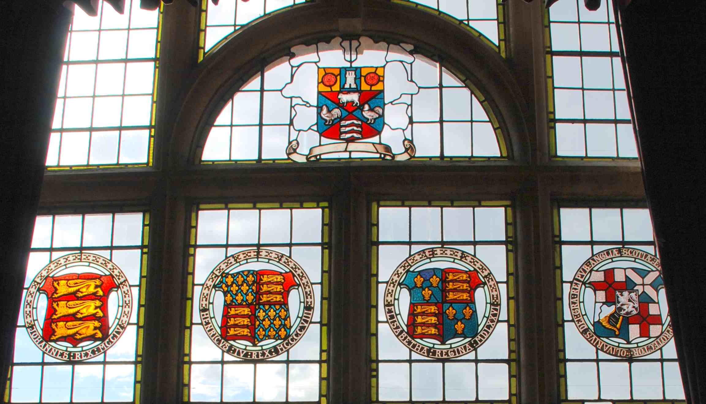 Balcony Windows shields - five stained glass panels set within leaded light windows within a stone mullioned frame